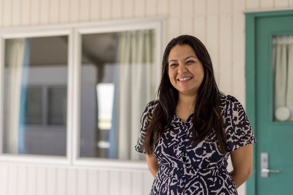 Programme facilitator stands outside building in prison